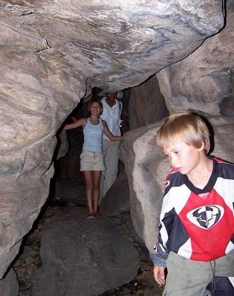 Markham, Macallan, and Nomsa expoloring a cave at Tsodilo
